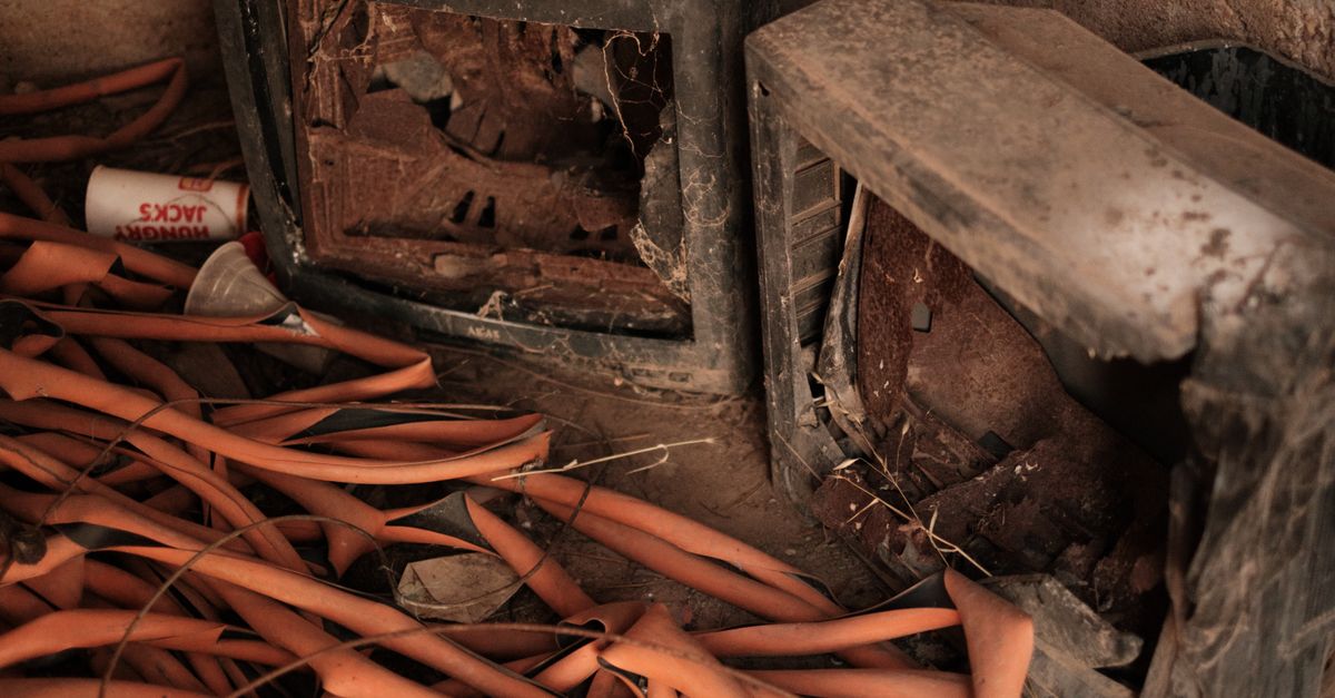 Old broken television sets and cables in a dusty, neglected environment.